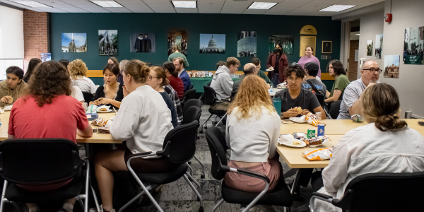 Photo shows the inside of the JMC Library with students and faculty sharing a meal during a Lunch Chat.