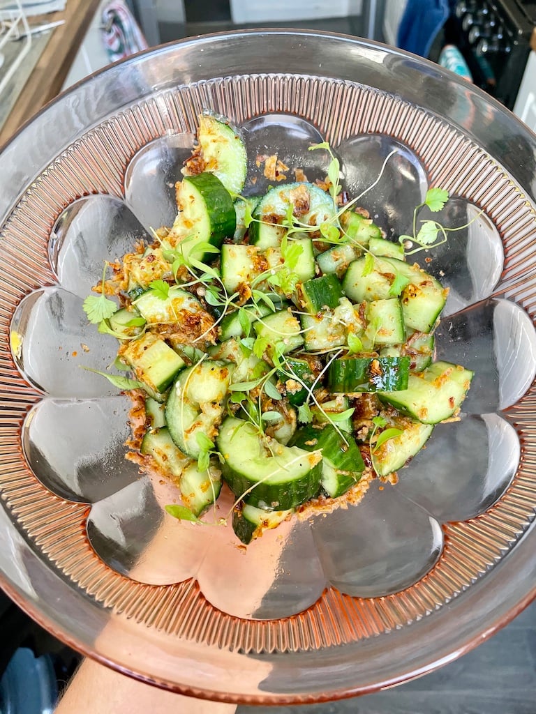 A cucumber salad in a pink bowl