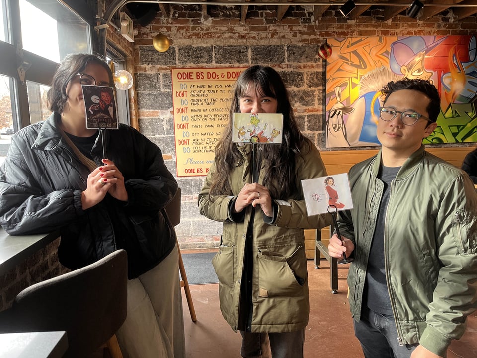 People holding Christmas-themed restaurant order cards.