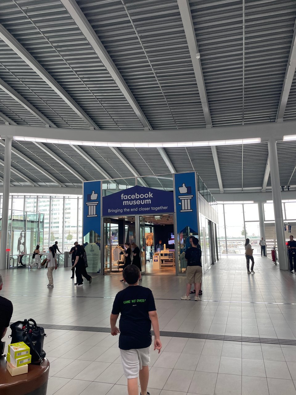 A young boy walks in a train station towards a pop-up museum called "Facebook Museum".