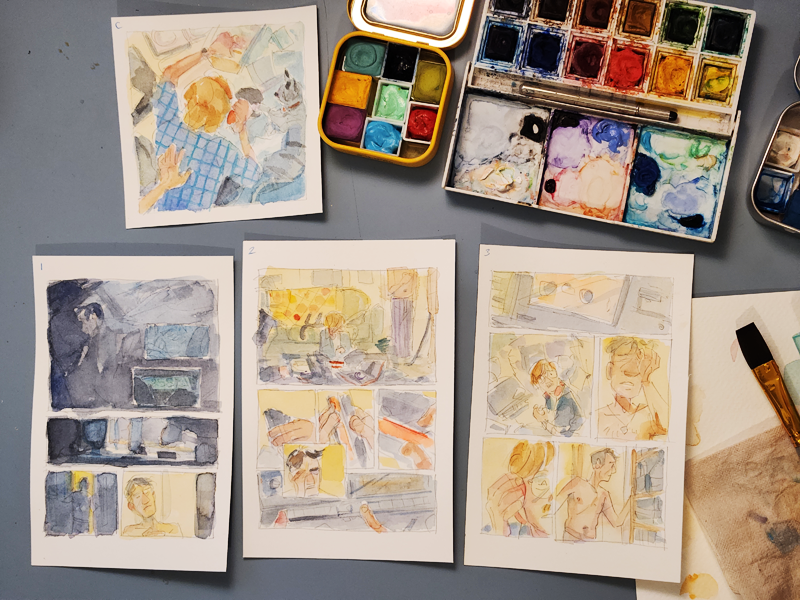 A photo of watercolour colour comps for four comic pages.