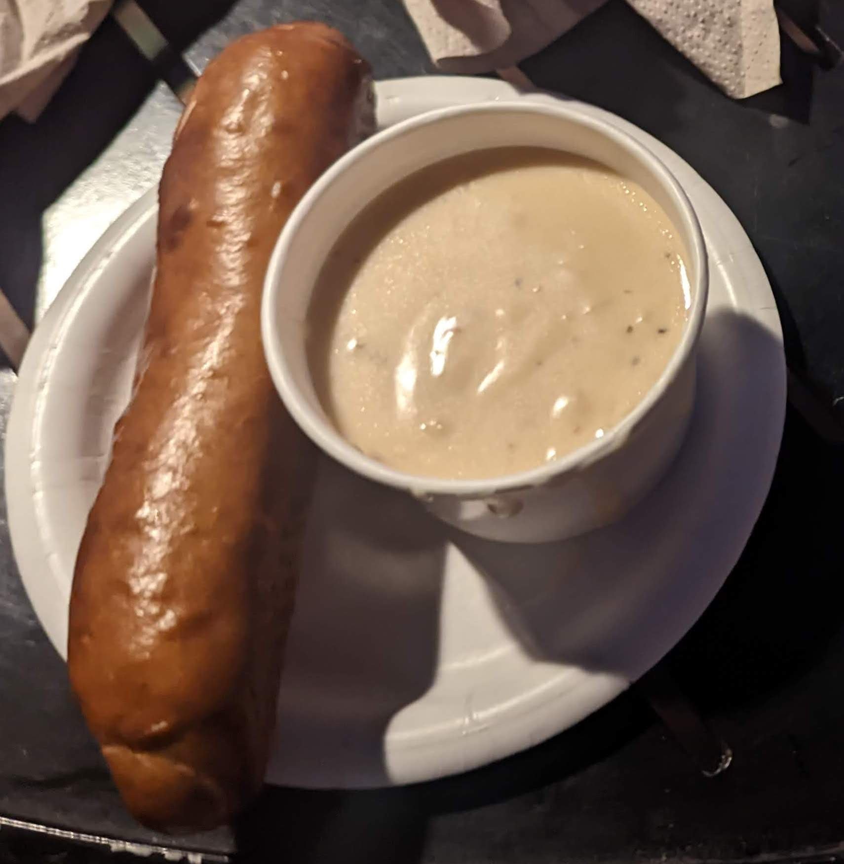 A shiny baguette accompanies a cheesy cup of soup