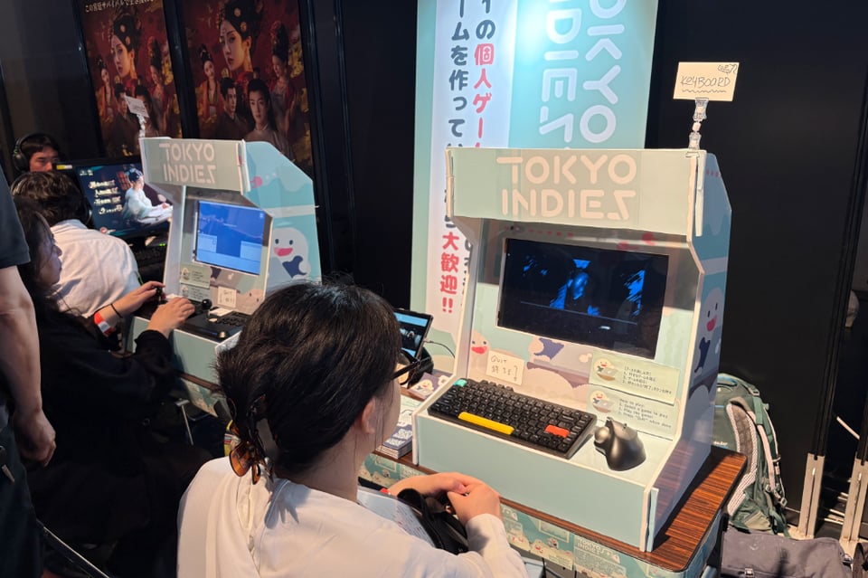 A bright blue handmade arcade booth. The text on the arcade says "Tokyo Indies.”