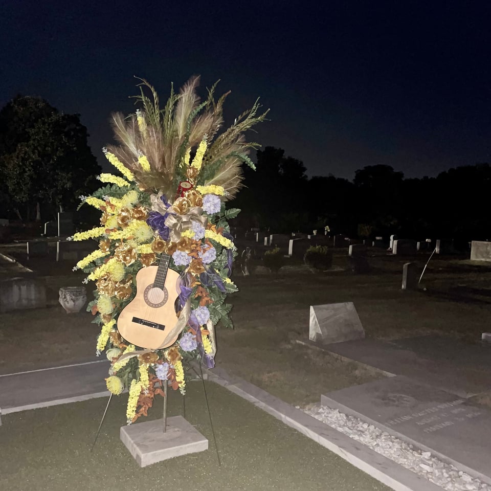 a view of the guitar and flowers tribute at Hank Williams' grave in Montgomery, Alabama