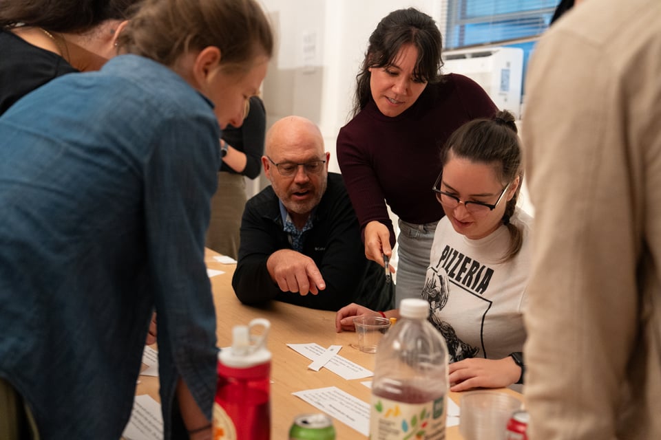 A group looking at pieces of paper.