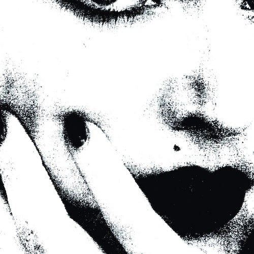 An extremely close up black and white picture of Madonna or someone who looks like her -- it may even be a blowup of a photocopy of a picture. All we can see is her nose, the bottom of her right eye, her lips, two of her fingers (with painted nails) holding her chin and cheek, and her lipstick'd lips.