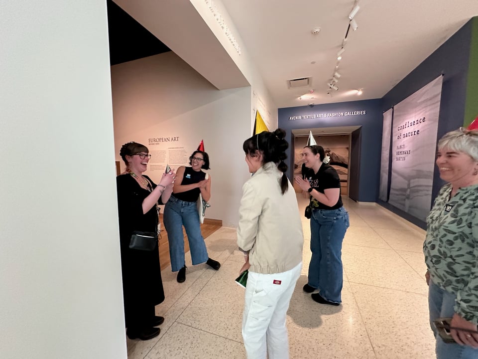 A hallway full of people wearing birthday hats.