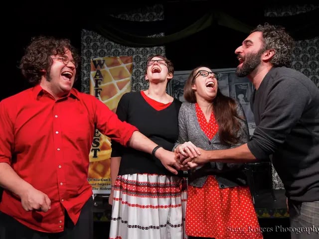 photo of PGraph on stage during WaffleFest, all holding hands and screaming.