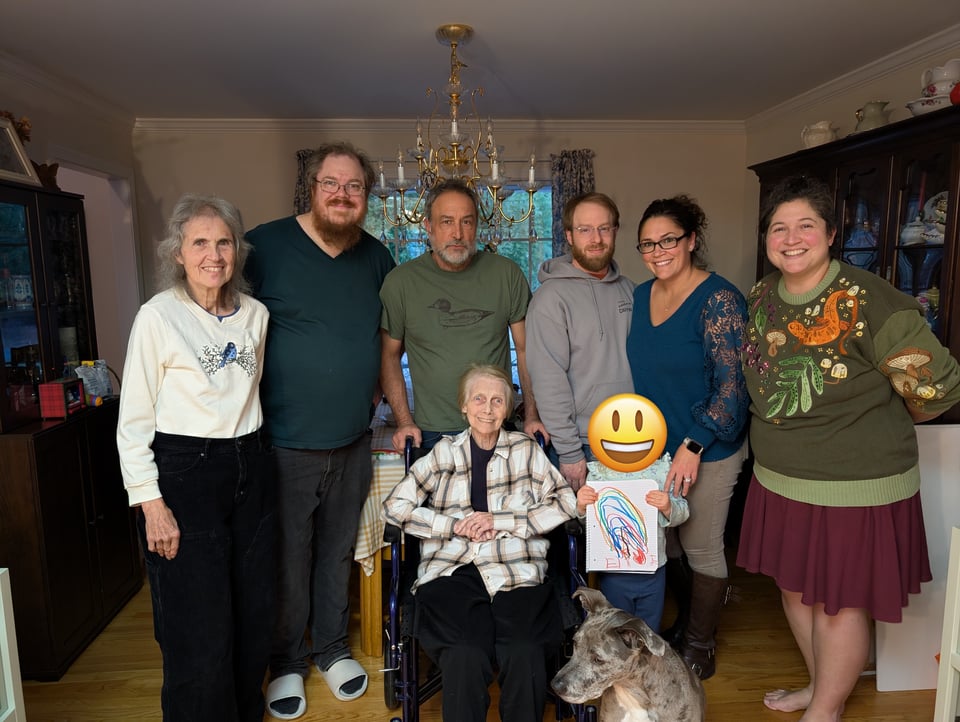 A family of white folks, with a dog in the front.