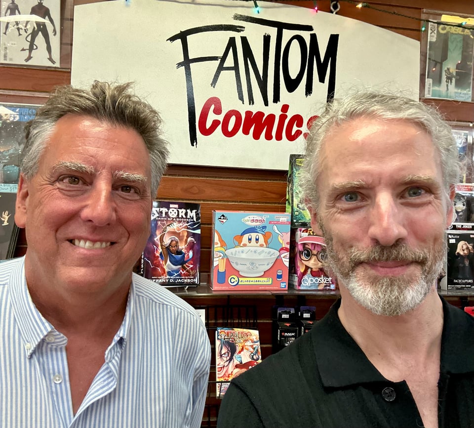Photo of two white men standing in front of the sign for Fantom Comics in Washington, DC