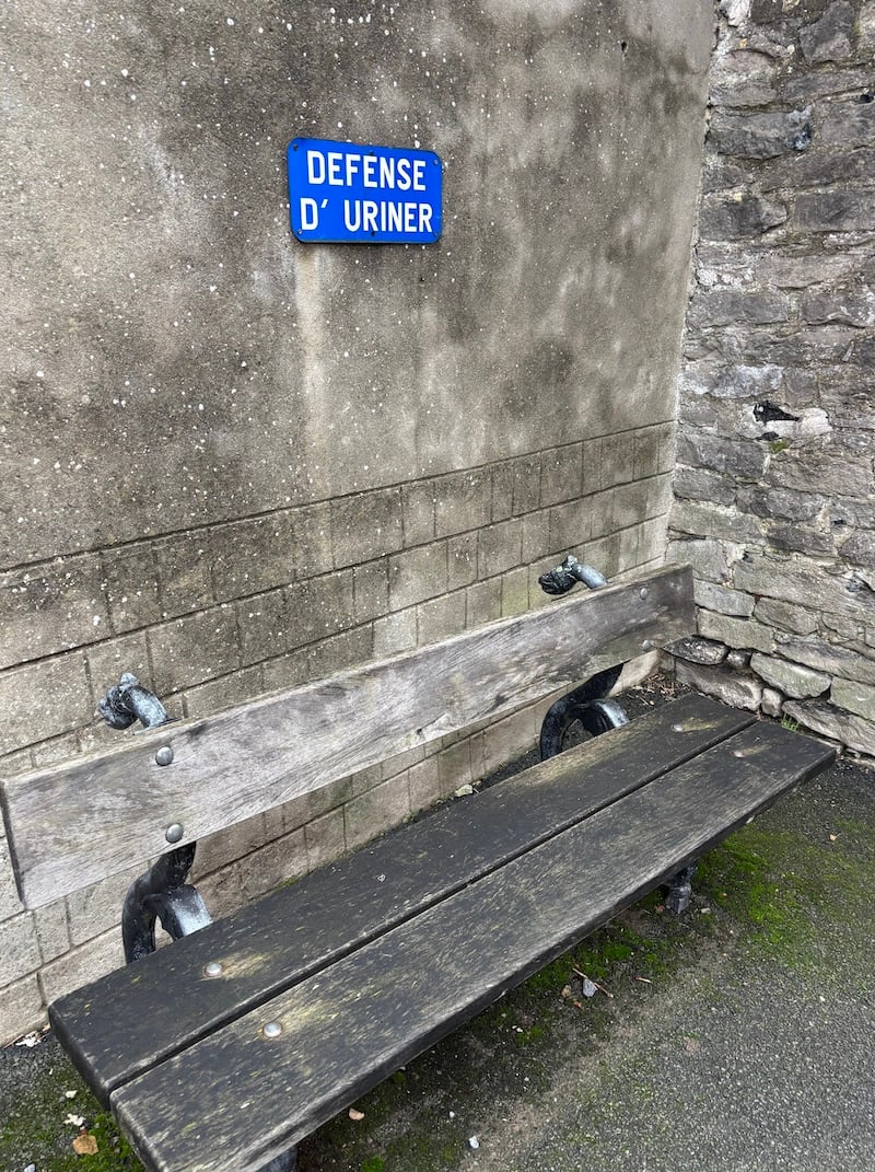 close-up of the bench, with a sign above it reading DEFENSE D'URINER