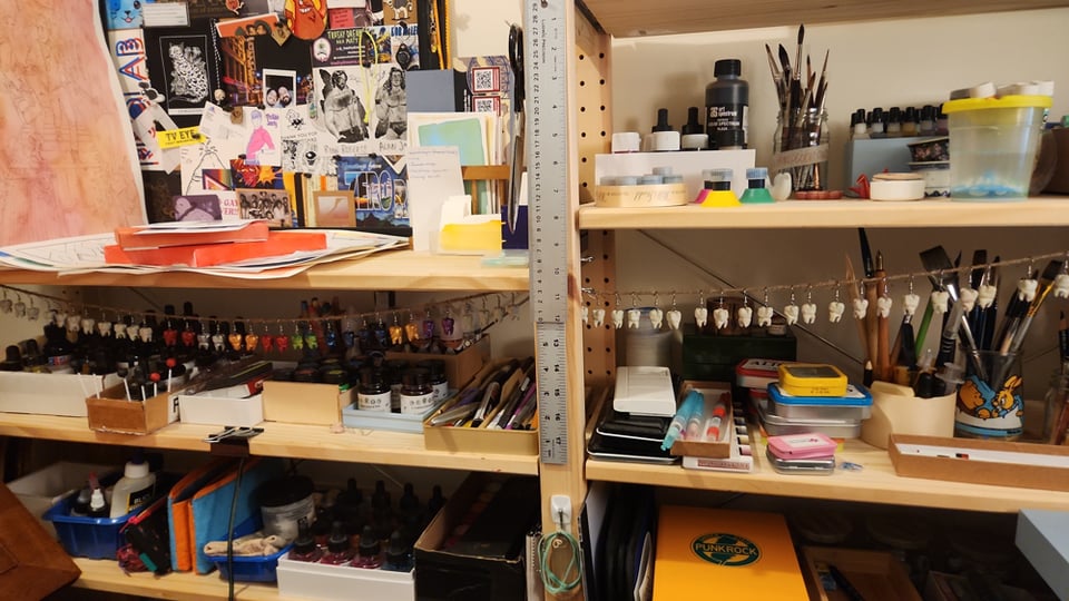 A photo of a lot of teeth hanging on strings amongst art supplies.