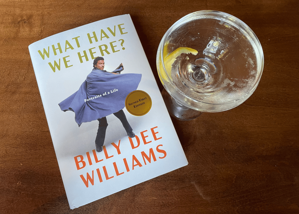 A book with Lando Calrissian on the cover next to a glowing martini with a twist