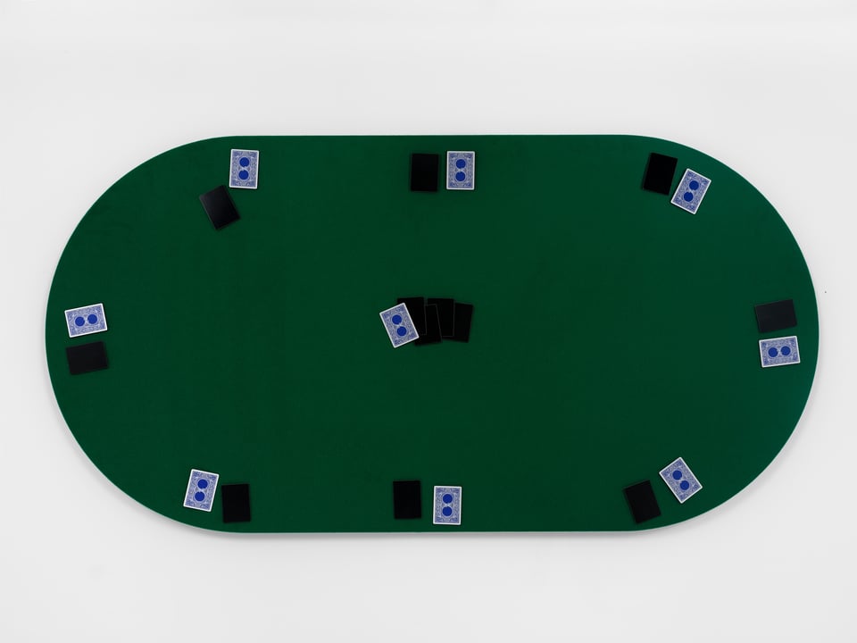 A poker table mounted on the wall, with cards on it as though a game were in progress, but all the card faces have been blacked out or redacted