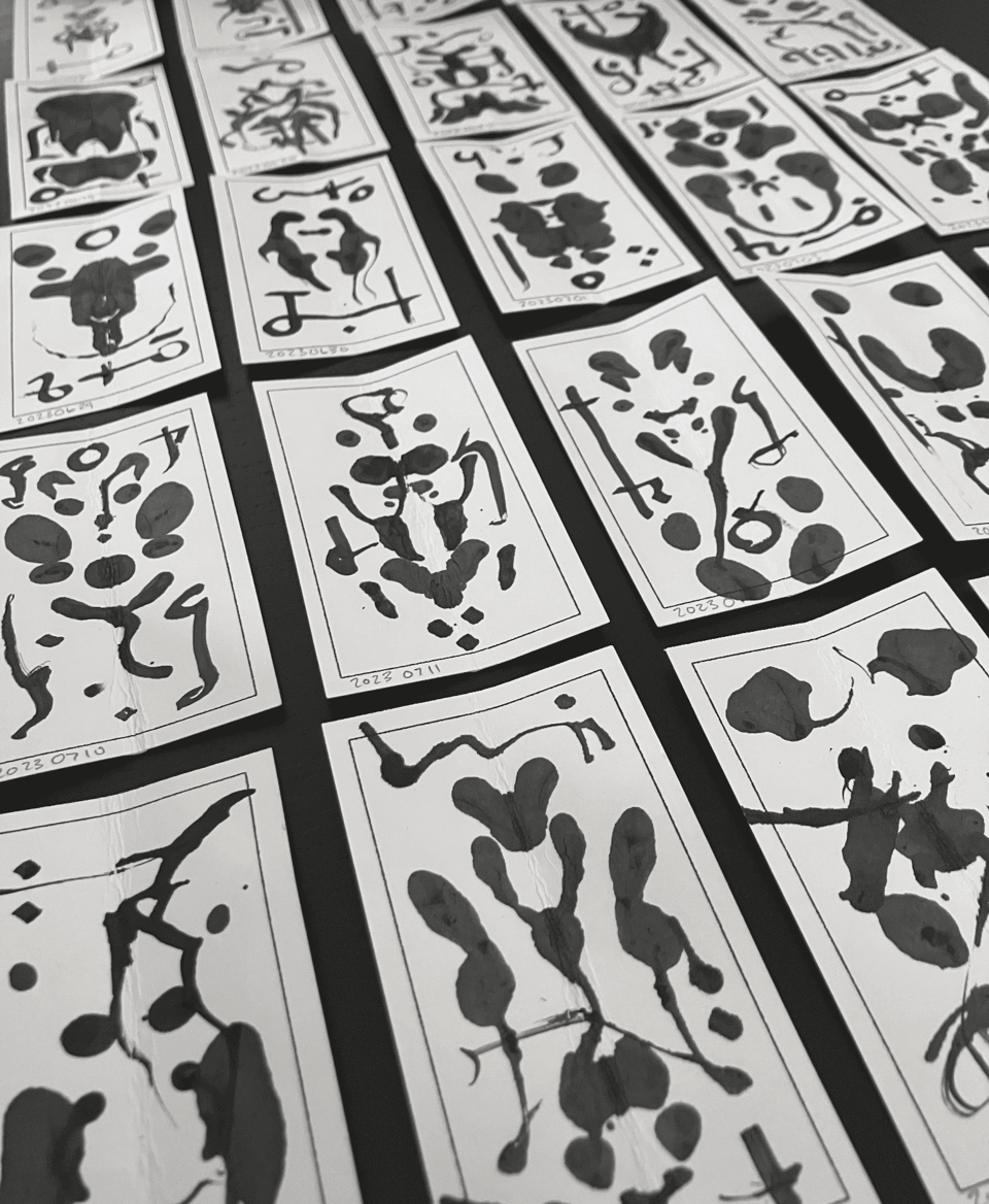 An array of small cards with automatic ink drawings on them.