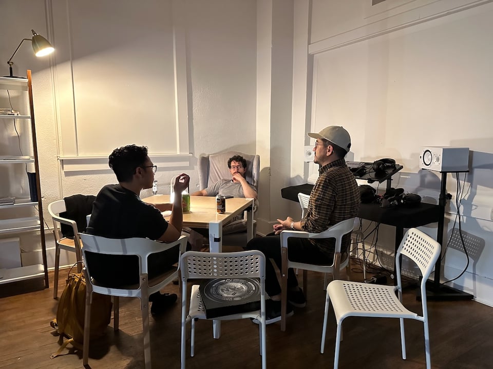 Norton, Ivan, and Justin sit around a table