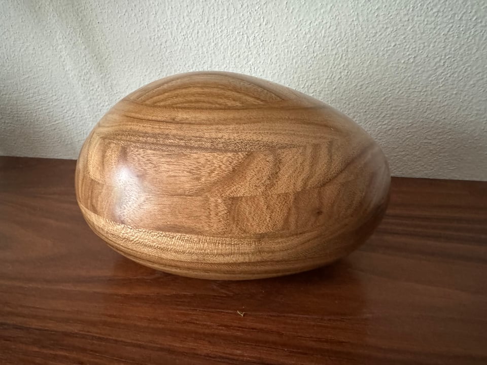 a river stone made of wood sits on a wood shelf