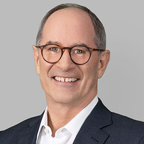 Photo, headshot of Roger Martin, middle-aged white man, wearing glasses, white colloared shirt, dark blazer