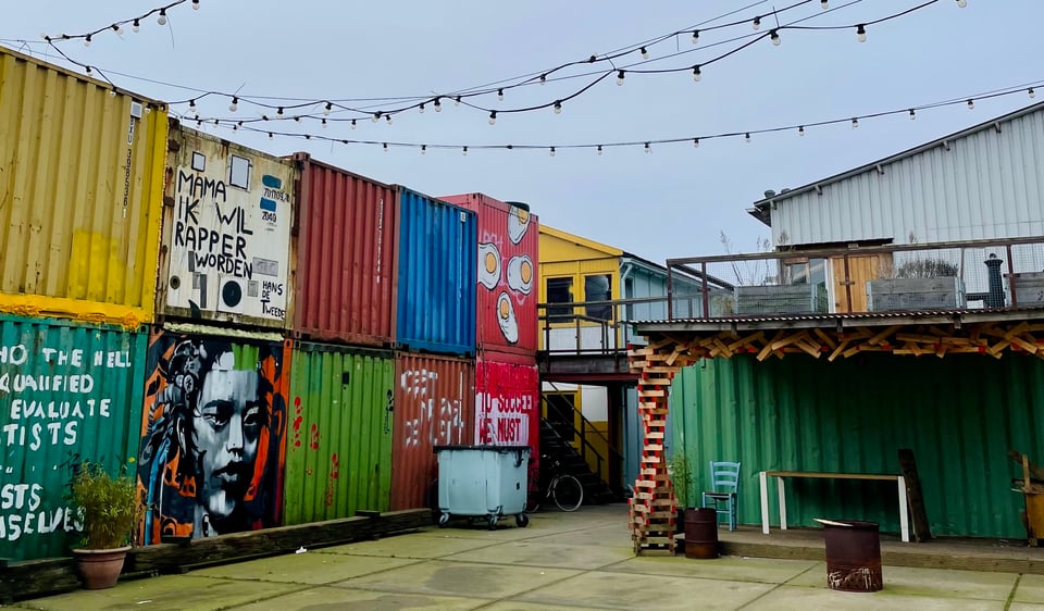 Colorful containers piled on top of each other at the Treehouse, and view of the courtyard as well as the small outside stage.