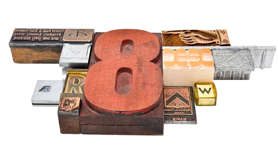 Set of type artifacts, including large wooden type 8, shown at an angle to the camera.