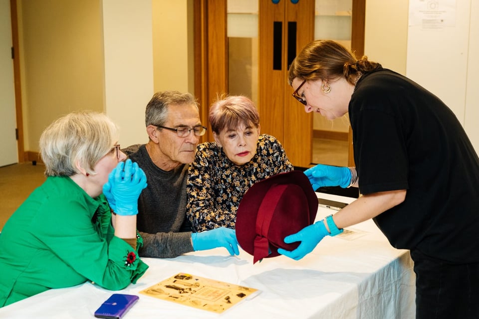 A group of people examining a hat