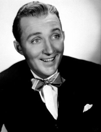 A black and white photo of Bing Crosby, aged perhaps 30, in a black jacket, white shirt and striped bow tie, smiling towards and to the right of the viewer