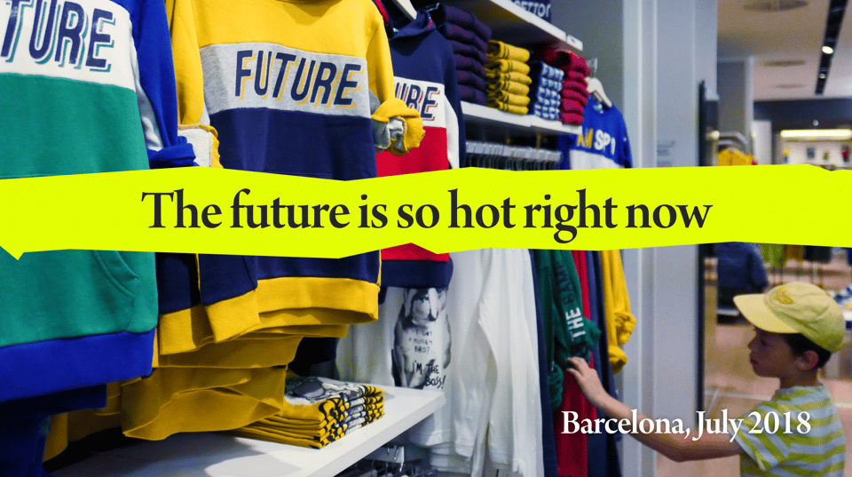 A boy in a clothes shop where all the clothes have 'Future' written on them