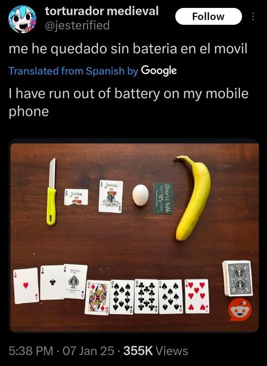 A post from at-jesterified on Twitter, display name torturador medieval. The tweet reads, me he quedado sin bateria en el movil. The translation from Spanish underneath reads, I have run out of battery on my mobile phone. There is a photo of a real-life Balatro setup with a knife, Joker card ripped in half, full Joker card, egg, Barnes and Noble gift card, and banana at the top of the picture, with a hand of cards with three aces selected and a face-down deck at the bottom.