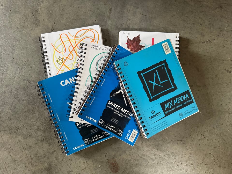 Stack of mixed media sketchbook journals