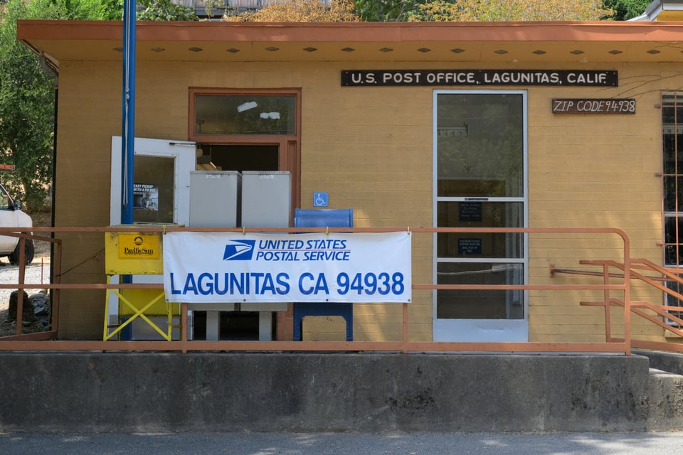 The front to the Lagunitas, CA post office, painted a nice yellow, with several signs indicating the zip code, 94938