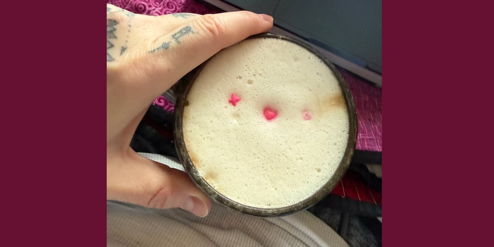 Coffee with candy hearts floating in the foam.