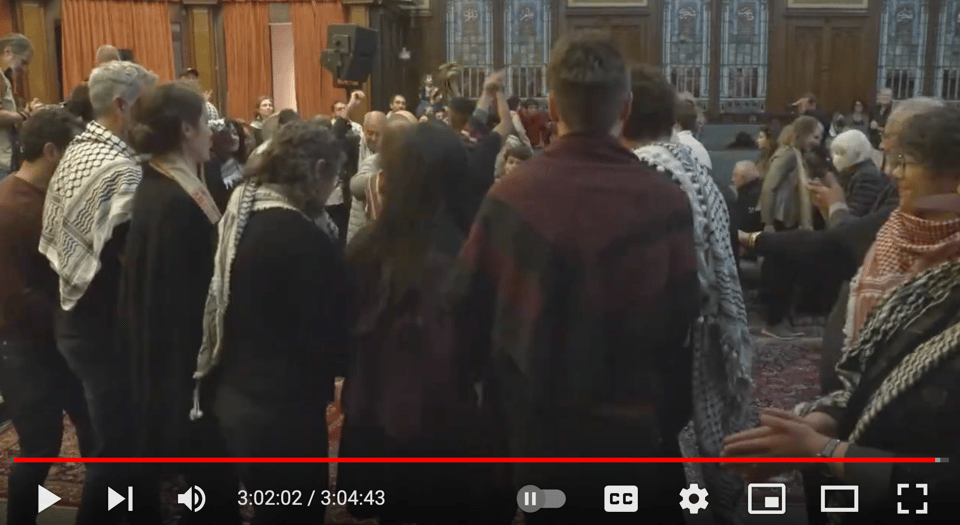 Image alt text: A still from a video of people dancing dabke