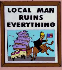 A framed newspaper headline from the simpsons: "Local Man Ruins Everything." Homer is drunk in a suit holding an american flag, riding backwards on a donkey that is ramming into and knocking over a five-layer cake.