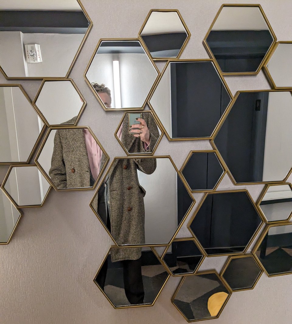 A selfie in a group of mirrors making me look broken apart and unconnected.
