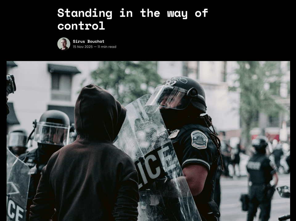 a hooded protestor stands face to face with a police officer in riot gear on the cover image for this new essay, titled "Standing in the way of control"