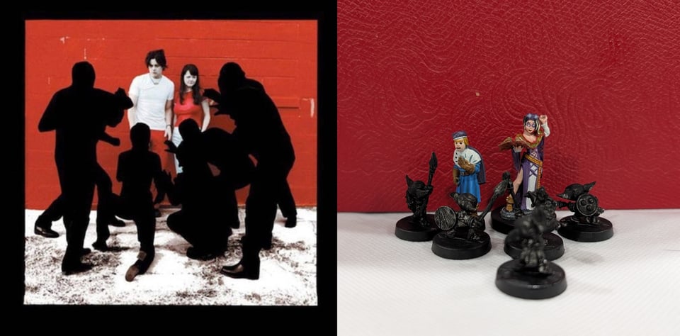 A color photo of The White Stripes: Jack, white man with black hair wearing a white t-shirt and red pants and Meg, a white woman with long black hair wearing a red shirt and white pants. They are standing against a red wall and are being menaced by six figures wearing all black and black hoods, turning them into silhouettes, like what stage puppeteers wear. The ground looks like it has white paint spilled over it. Jack looks a little unnerved, but Meg is inscrutable, which is normal for her.