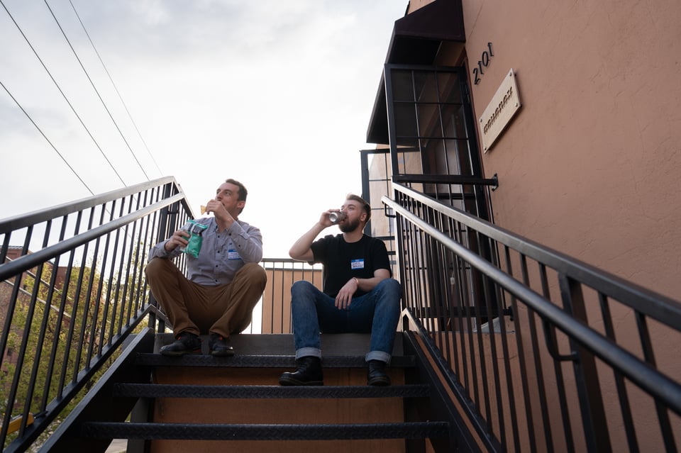 Mike and Chris sitting on the steps of The Company.