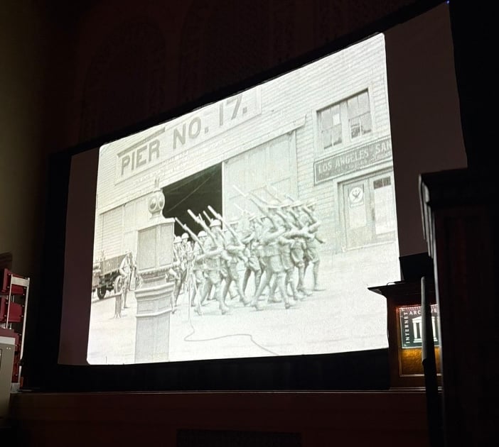 Home movies of the National Guard occupying San Francisco in July 1934 during the West Coast Waterfront Strike from the Scott Stark Collection. Image of troops marching in front of Pier No. 17., recording themselves.