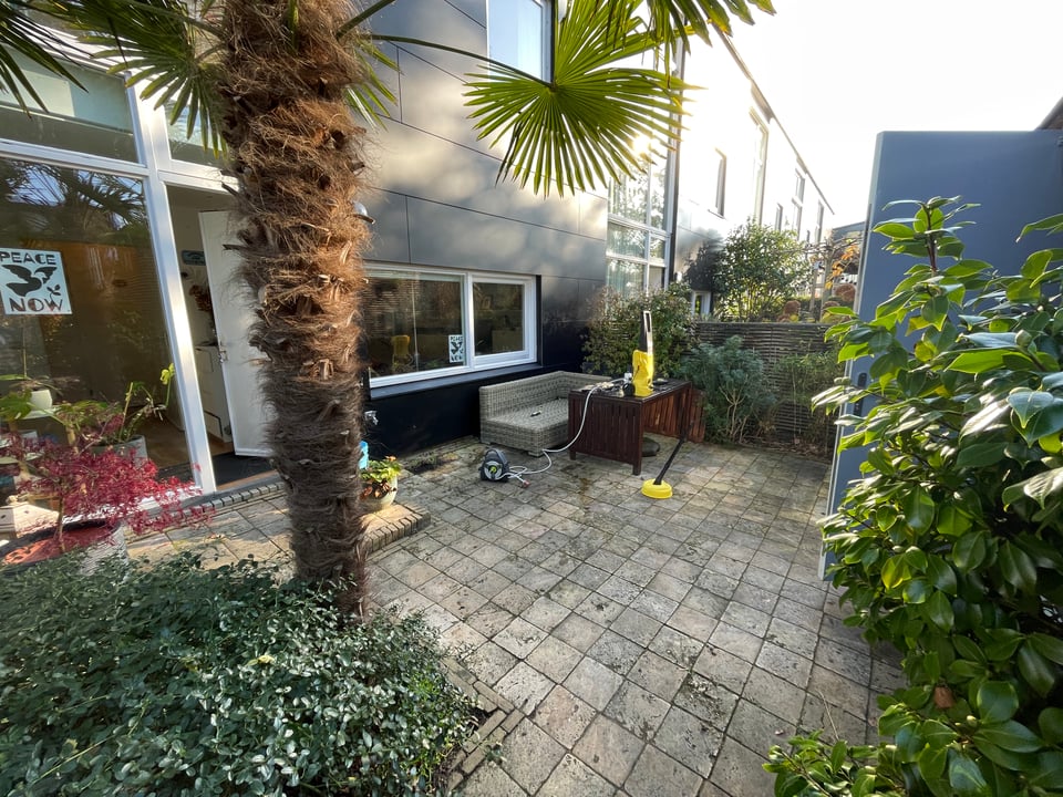 A dirty patio is prepared for pressure washing.