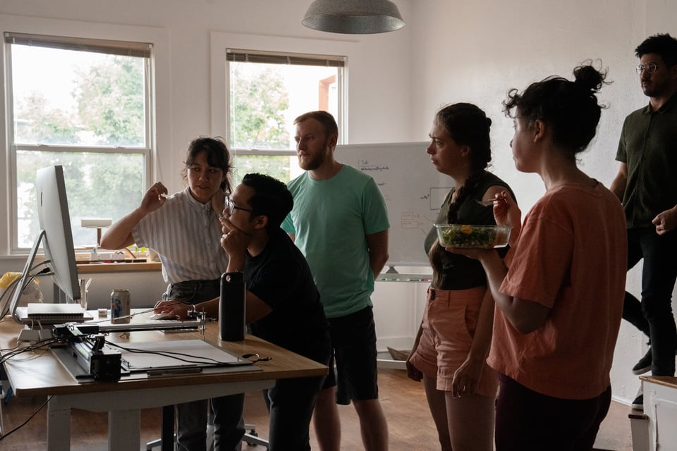 A group of people studying a screen intently.