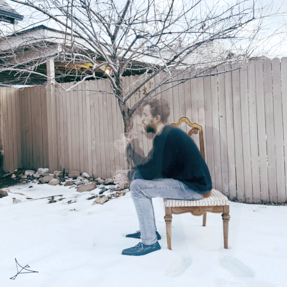 multiple exposure photo of dave sitting on a chair in front of a tree, snow is on the ground