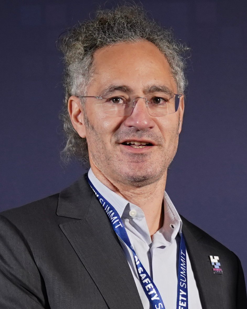 Photo of Alex Karp standing in front of a gray background. Image via https://www.flickr.com/photos/192333790@N05/53302457013/