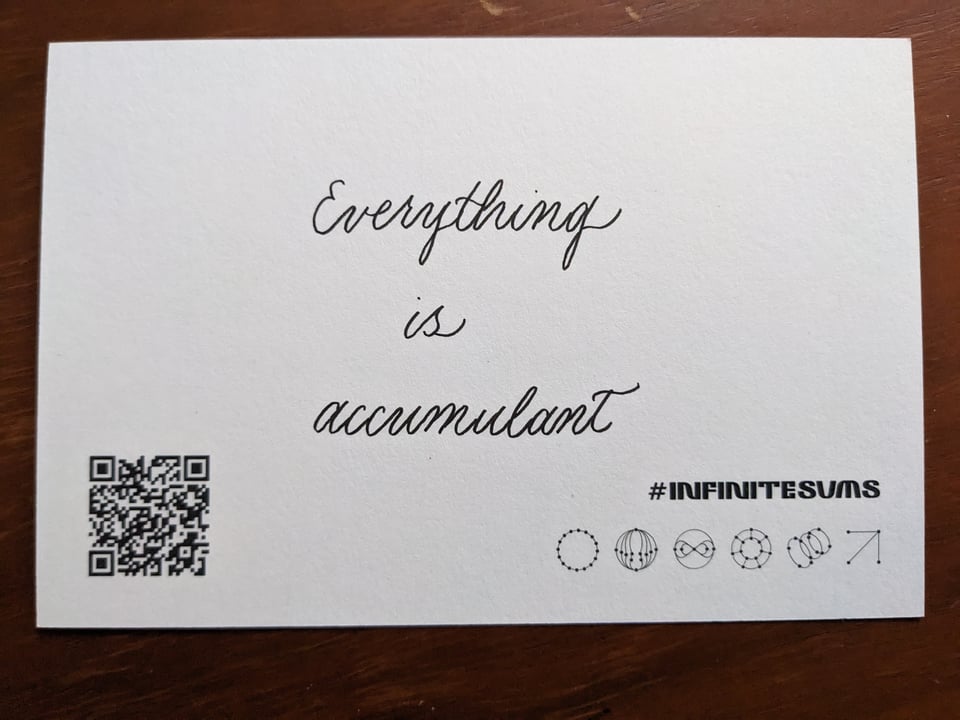 a postcard that has a poem in calligraphy "Everything / is / accumulant?"