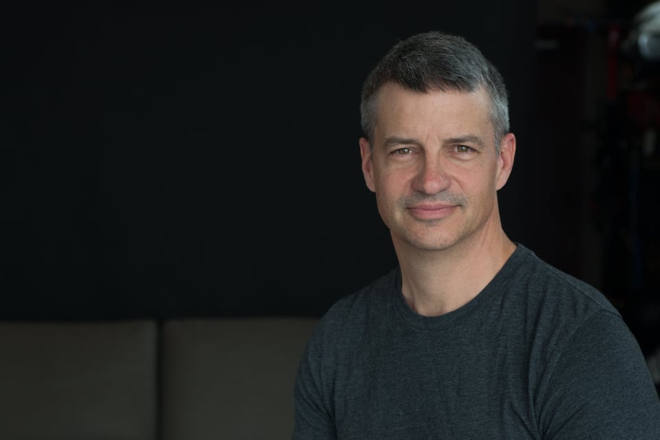 Artist Kirk Dunn (a white man) is wearing a grey t-shirt.