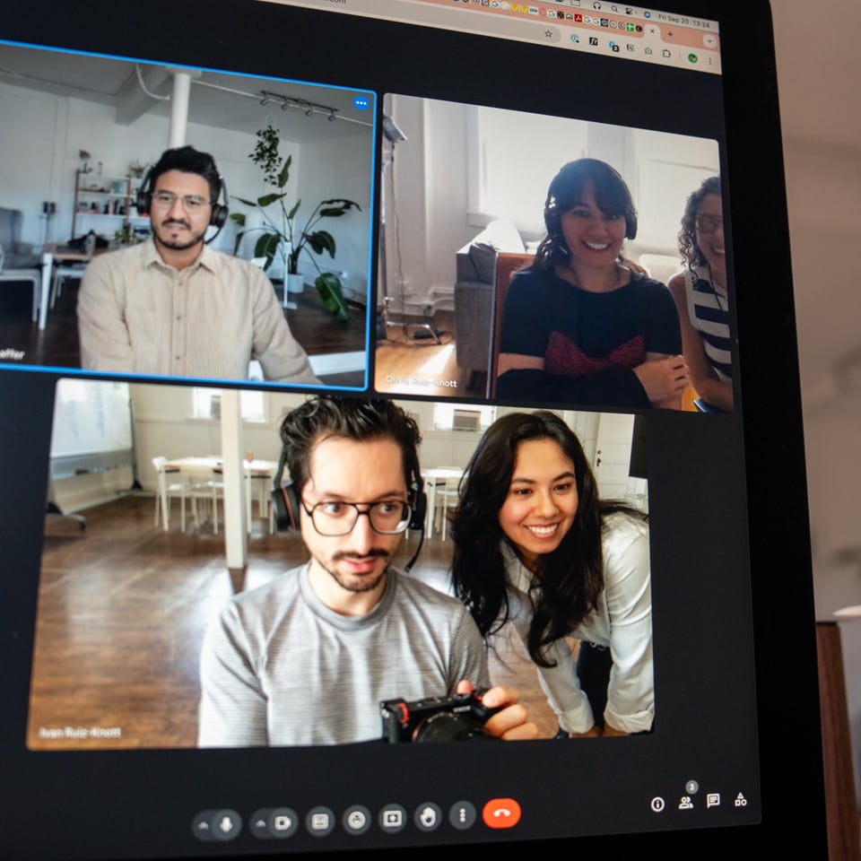 A bunch of people in the same room on a video call with each other.