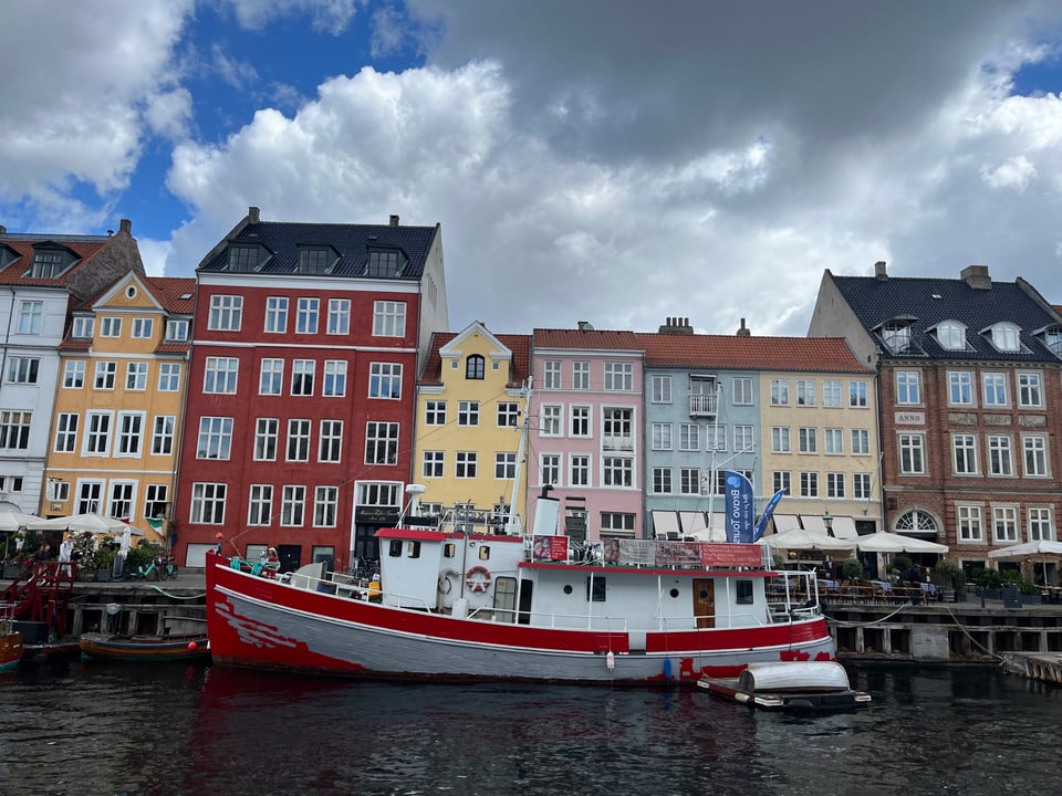 Cute colorful buildings and a boat in a canal from Nyhavn in Copenhagen 