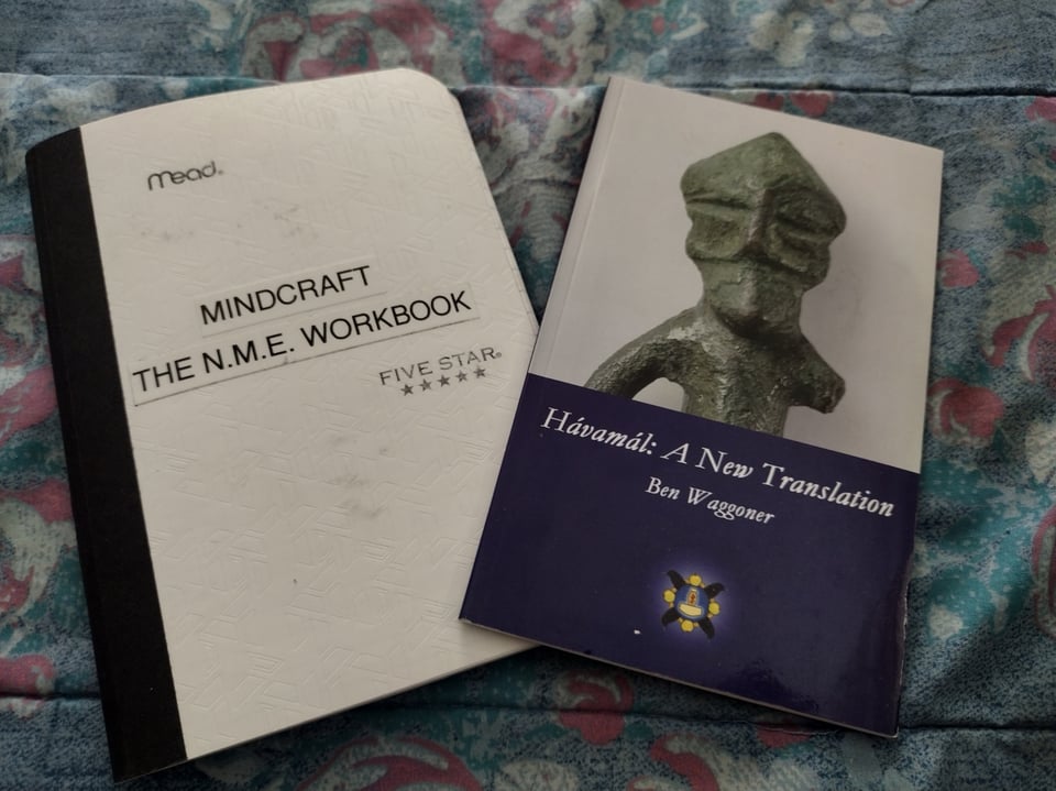 A Small copy of The Havamal translated by Ben Waggoner next to the MindCraft/N.M.E. Workbook.