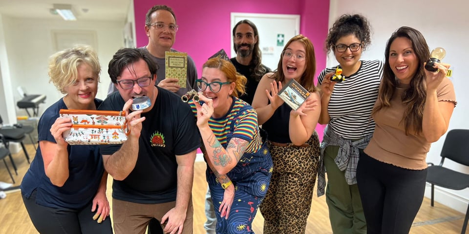 The Pretend Ensemble in Southend all holding up objects.