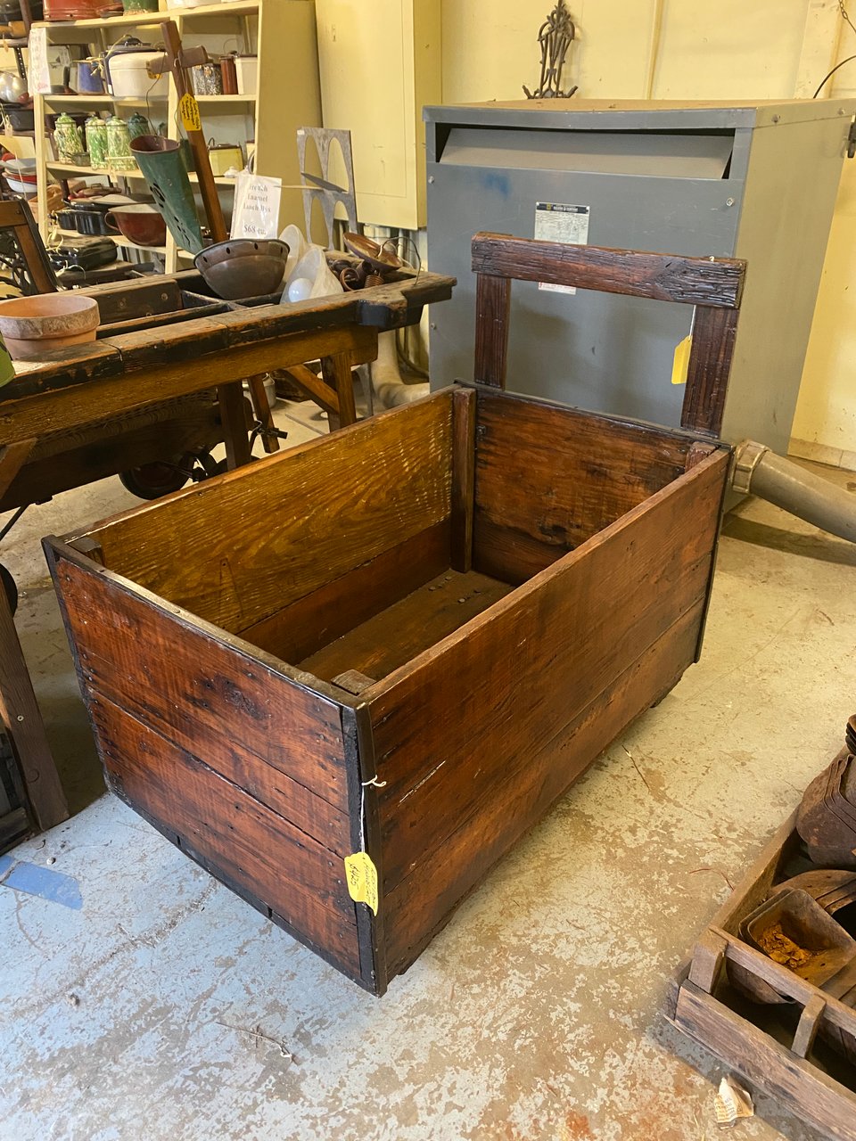 A 100+-year old ore cart made out of wood, surrounded by other antique salvage junk