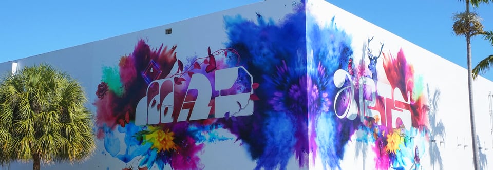 Mural that says Mad Arts on the exterior of a white building.